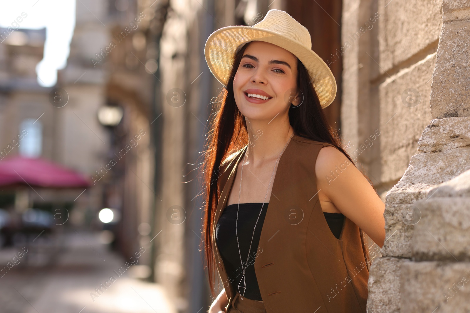 Photo of Beautiful young woman in stylish hat on city street