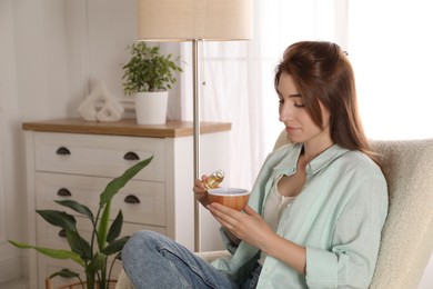 Woman adding essential oil to aroma diffuser at home