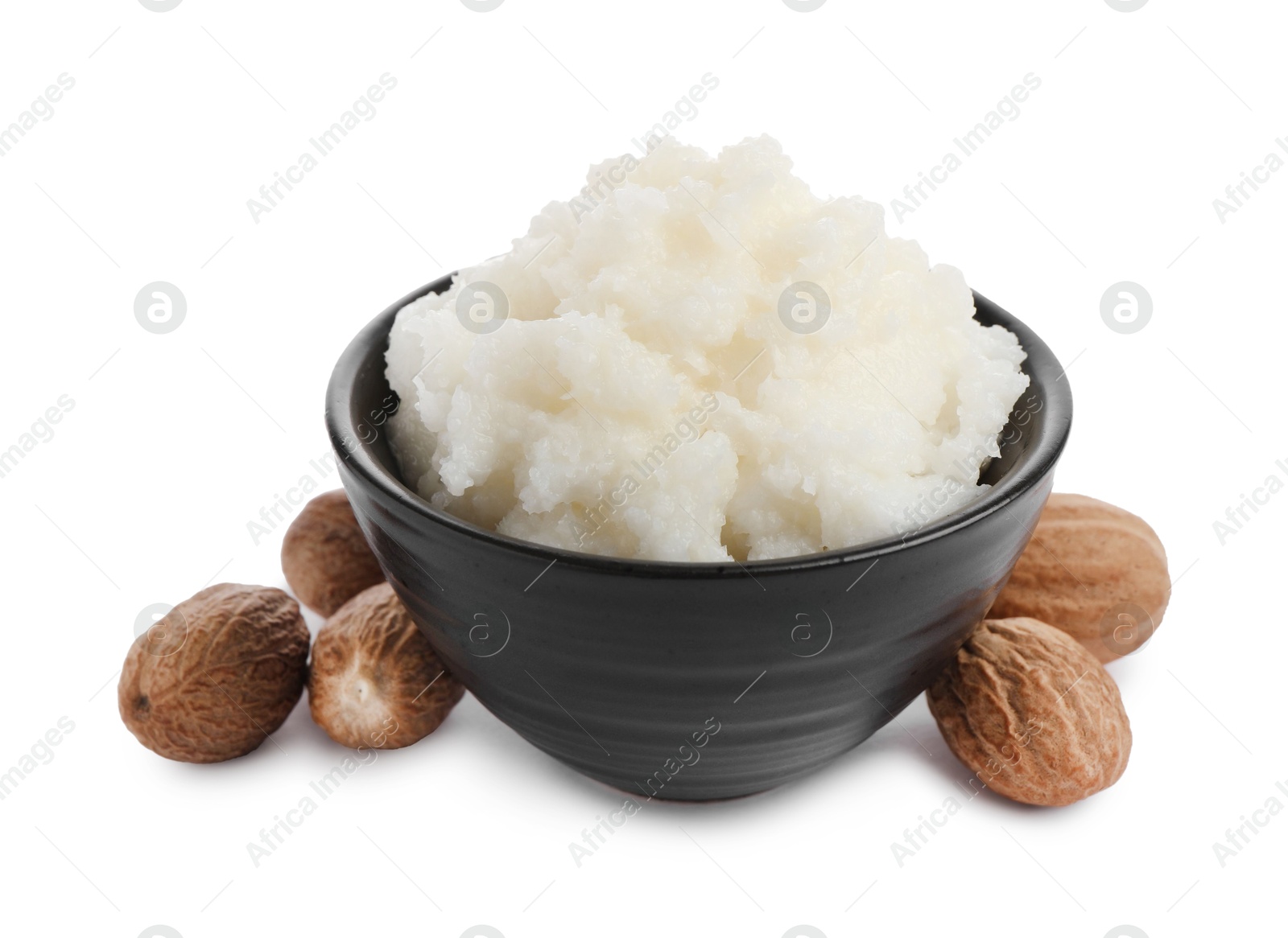 Photo of Natural shea butter in bowl and nuts isolated on white