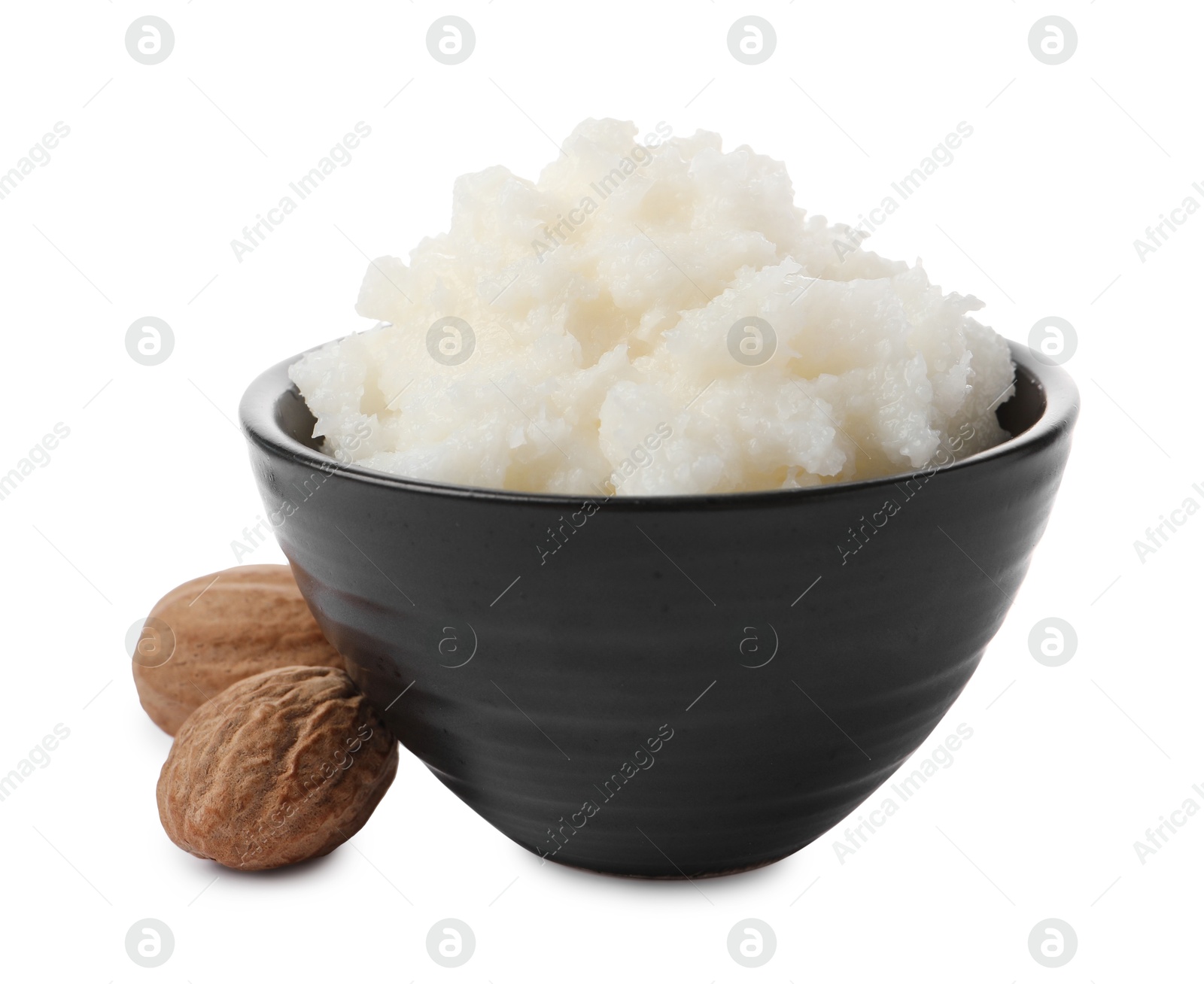 Photo of Natural shea butter in bowl and nuts isolated on white