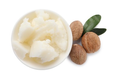 Natural shea butter in bowl, nuts and green leaves isolated on white, top view