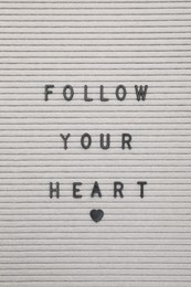 Photo of Letter board with phrase Follow your heart as background, top view