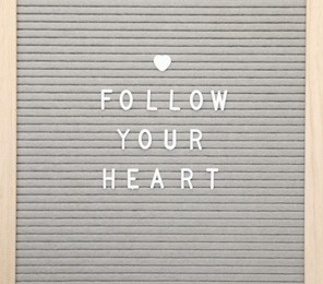 Photo of Letter board with phrase Follow your heart on white background, top view