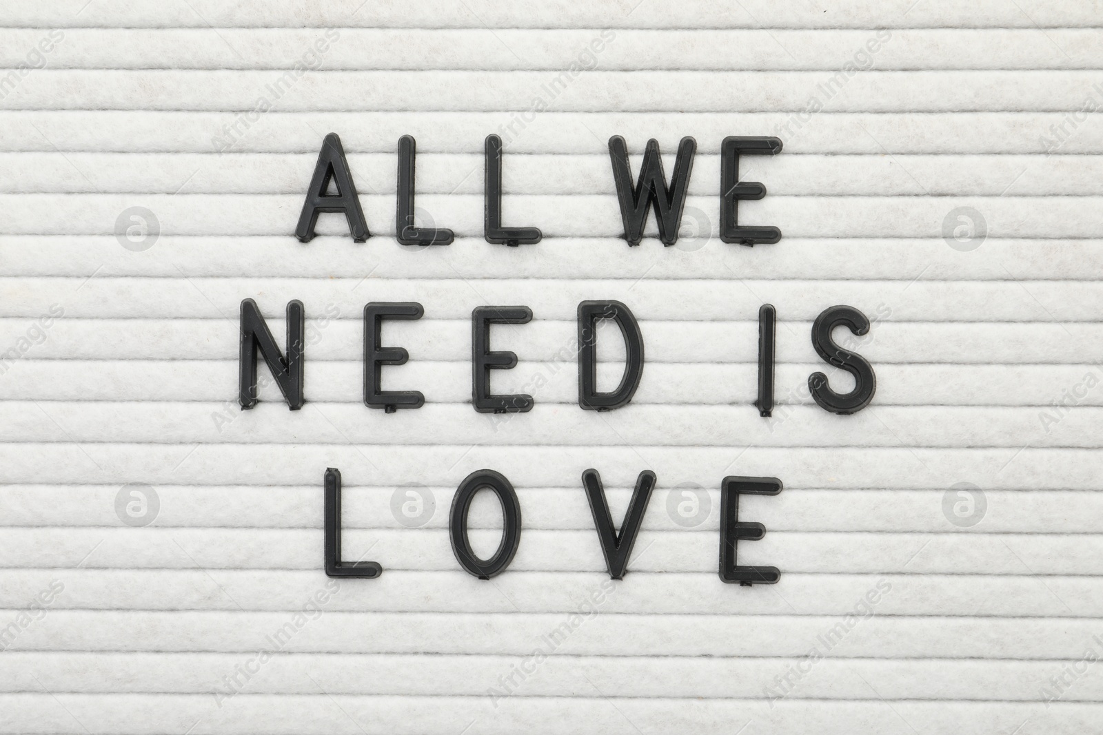 Photo of Letter board with phrase All we need is love as background, top view