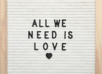 Letter board with phrase All we need is love on white background, top view