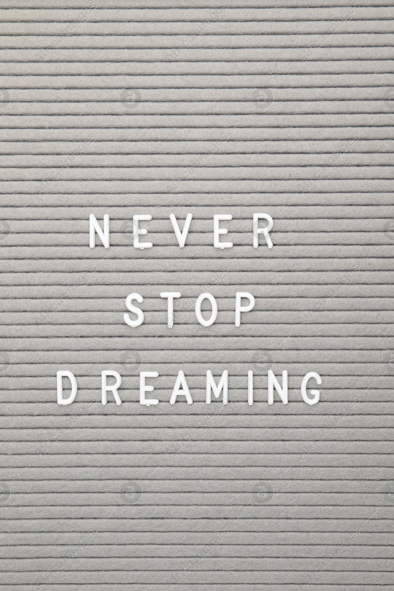 Photo of Letter board with phrase Never stop dreaming as background, top view