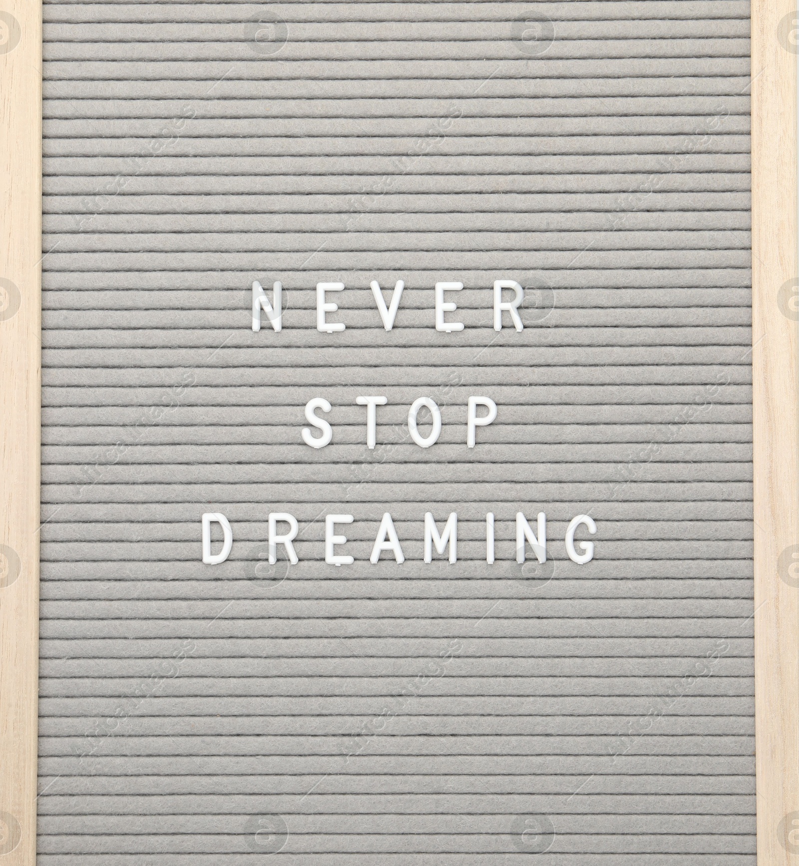 Photo of Letter board with phrase Never stop dreaming on white background, top view