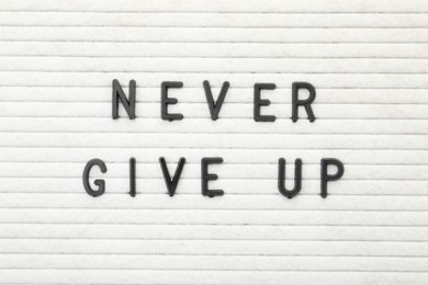 Photo of Letter board with phrase Never give up as background, top view