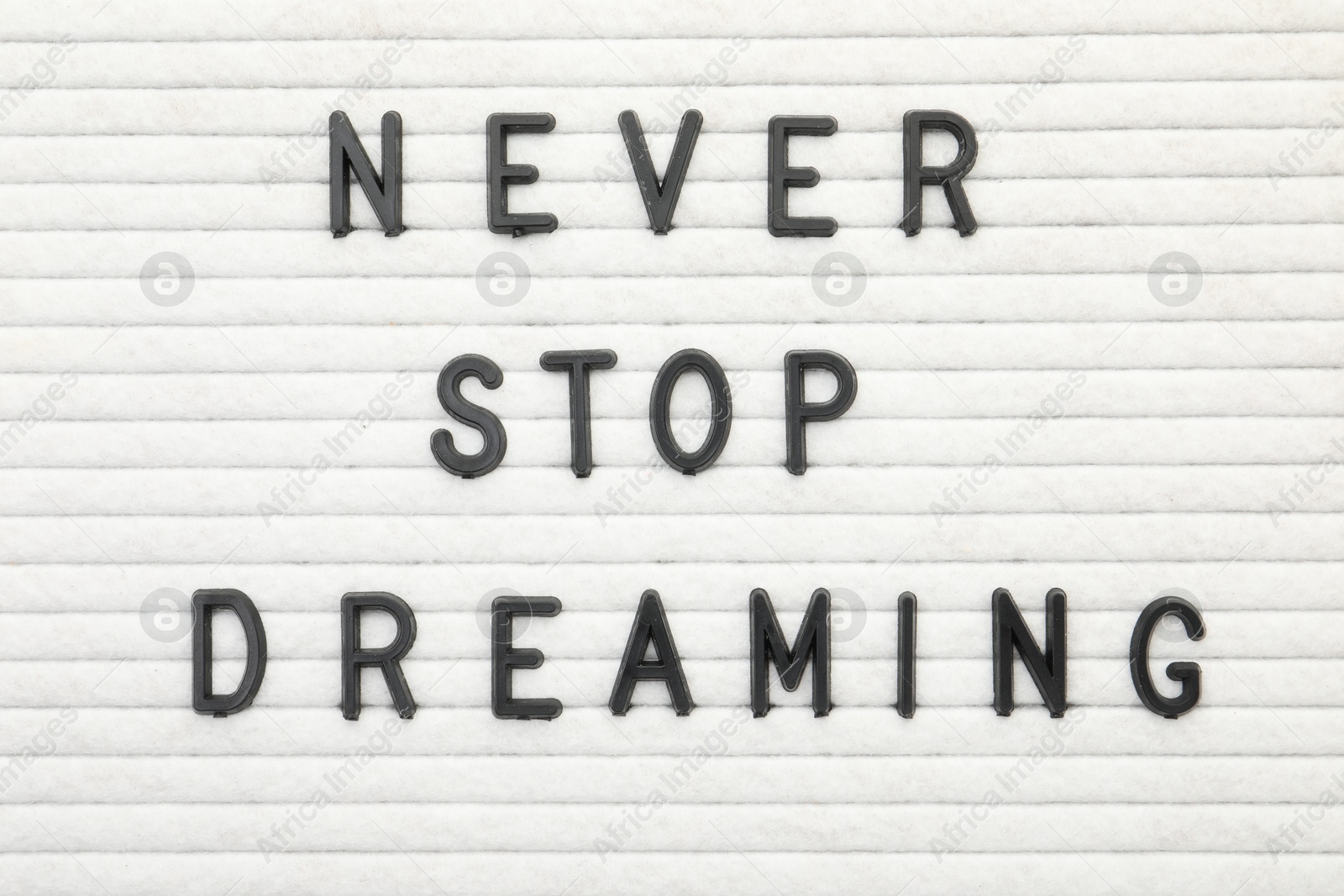 Photo of Letter board with phrase Never stop dreaming as background, top view