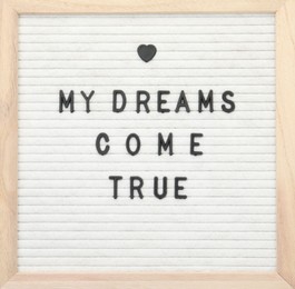 Photo of Letter board with phrase My dreams come true on white background, top view