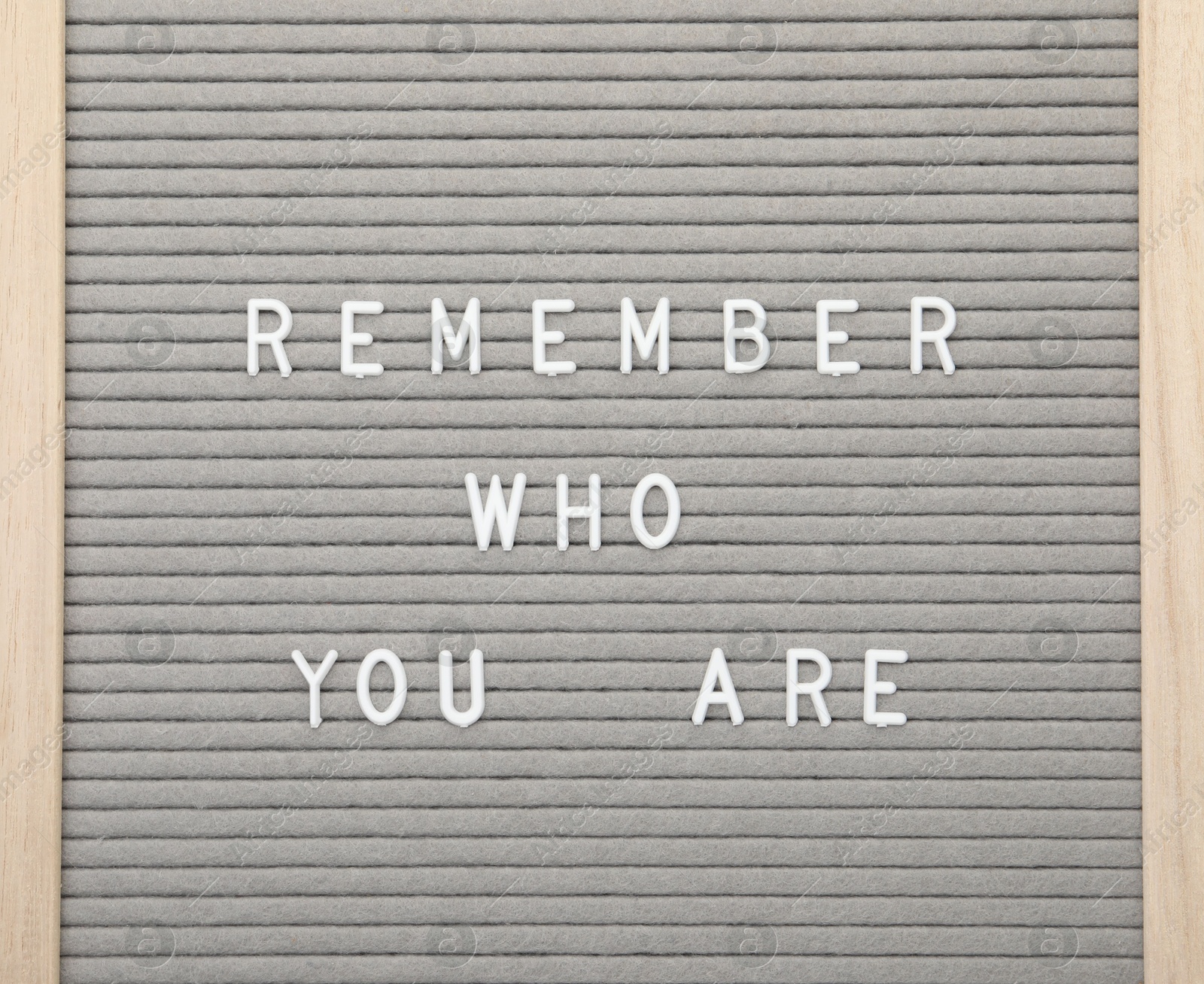 Photo of Letter board with phrase Remember who you are on white background, top view