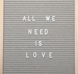 Photo of Letter board with phrase All we need is love on white background, top view