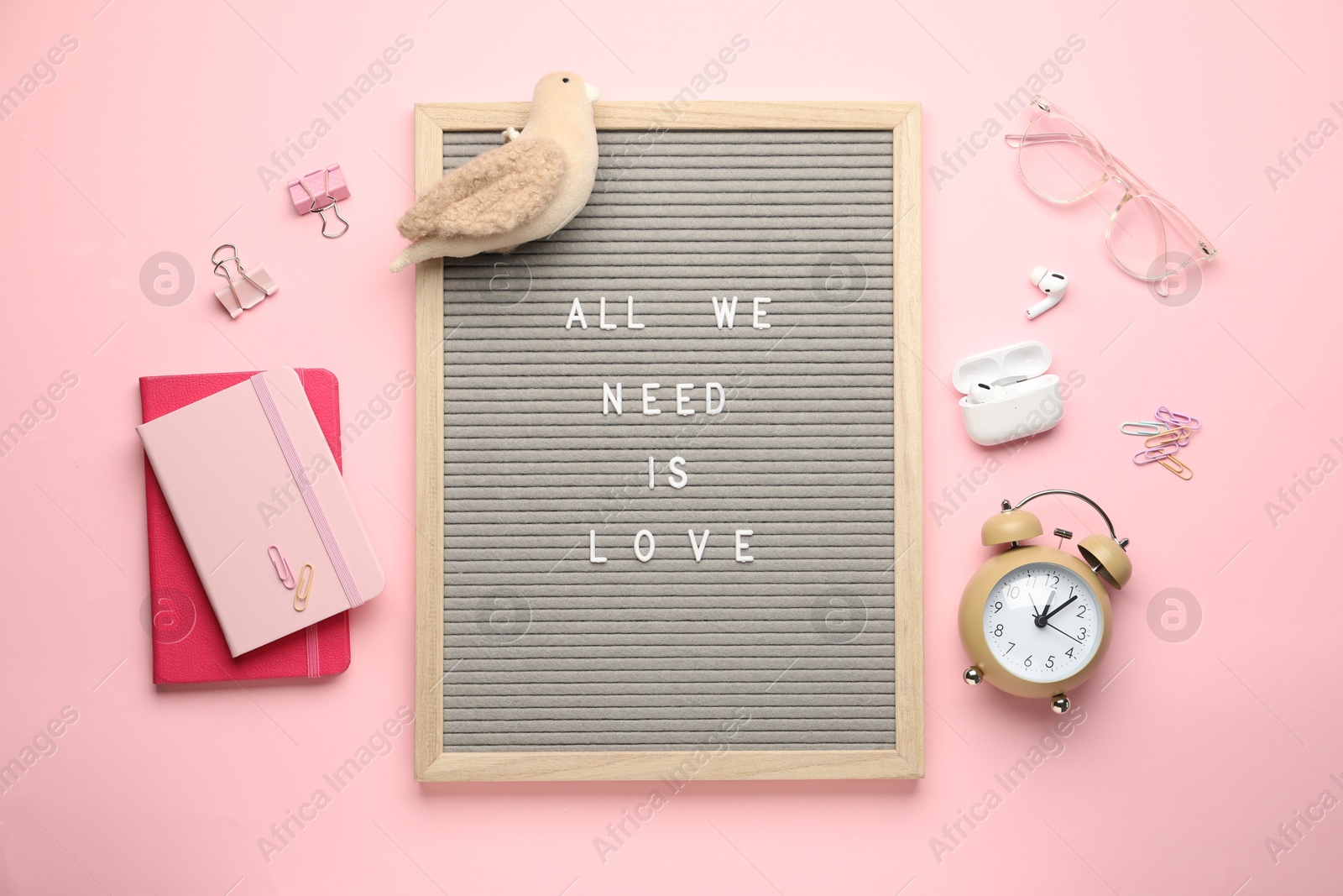 Photo of Flat lay composition of letter board with phrase All We Need Is Love on pink background