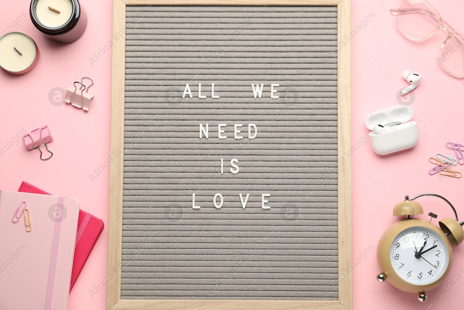 Photo of Flat lay composition of letter board with phrase All We Need Is Love on pink background