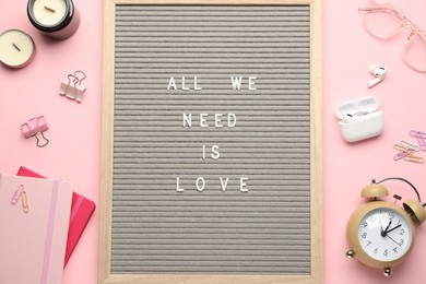 Photo of Flat lay composition of letter board with phrase All We Need Is Love on pink background