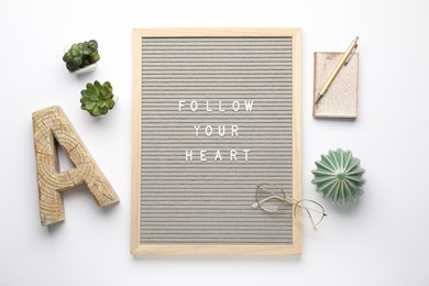 Photo of Flat lay composition of letter board with phrase Follow Your Heart on white background