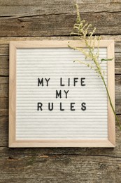 Letter board with phrase My Life My Rules and beautiful flower on wooden table, top view