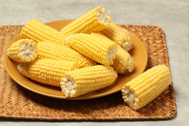 Halves of fresh ripe corncobs on grey table