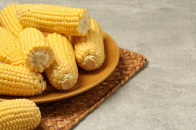 Halves of fresh ripe corncobs on grey table, closeup. Space for text