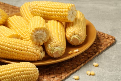 Halves of fresh ripe corncobs on grey table, closeup