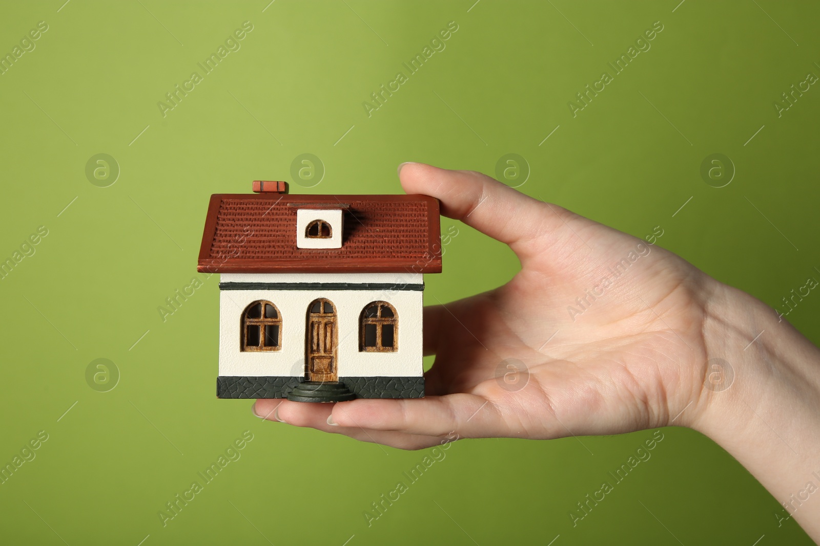 Photo of Woman with house model on green background, closeup