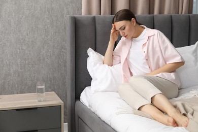 Woman suffering from menstrual pain on bed at home