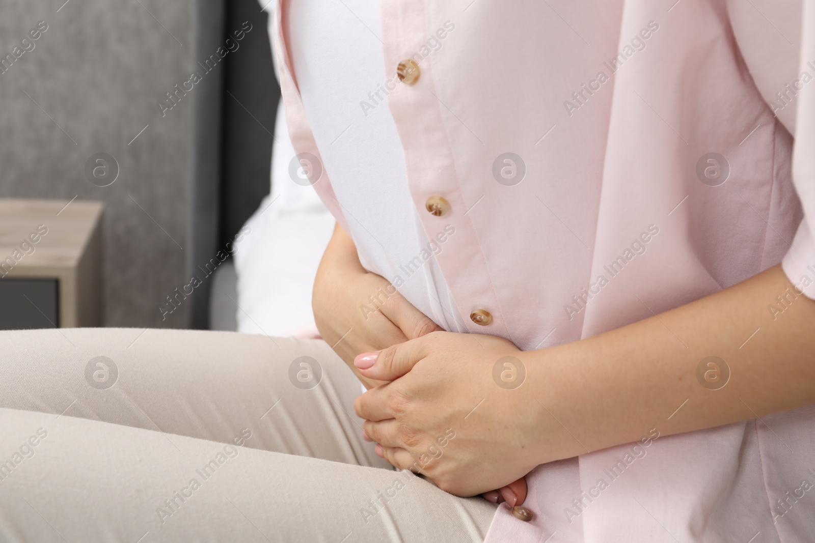 Photo of Woman suffering from menstrual pain at home, closeup