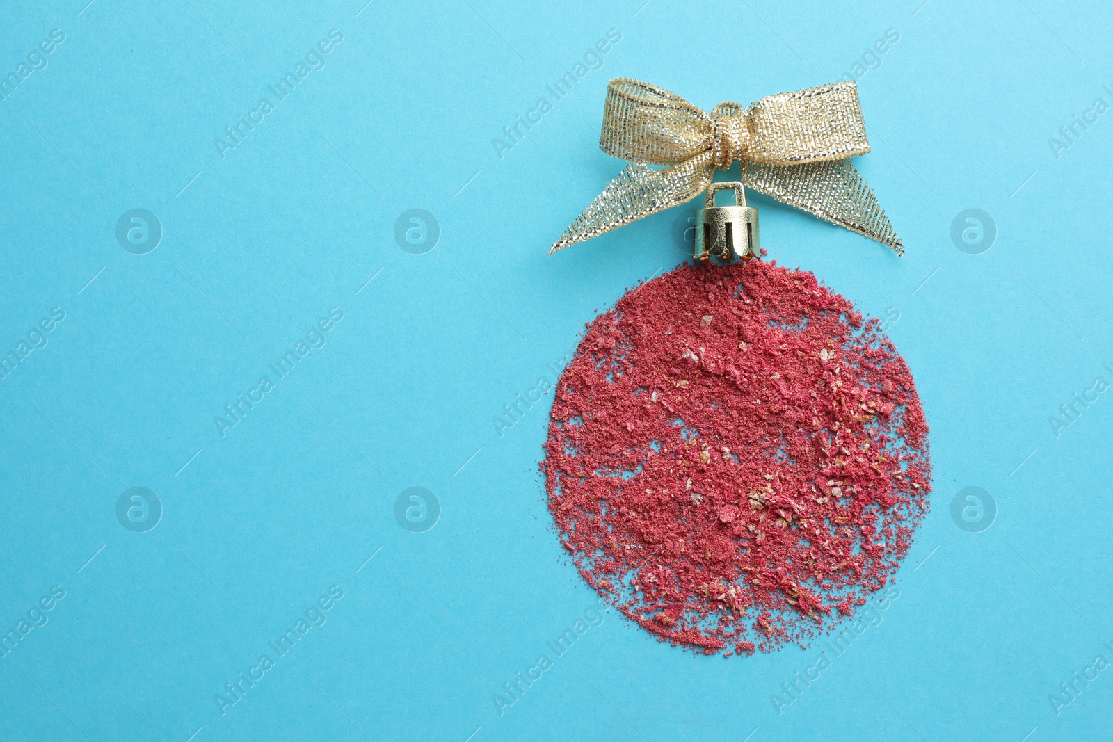 Photo of Christmas ball made with blush on light blue background, top view. Space for text