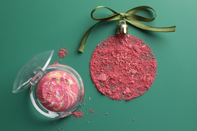 Photo of Christmas ball made of blush and bow on green background, top view