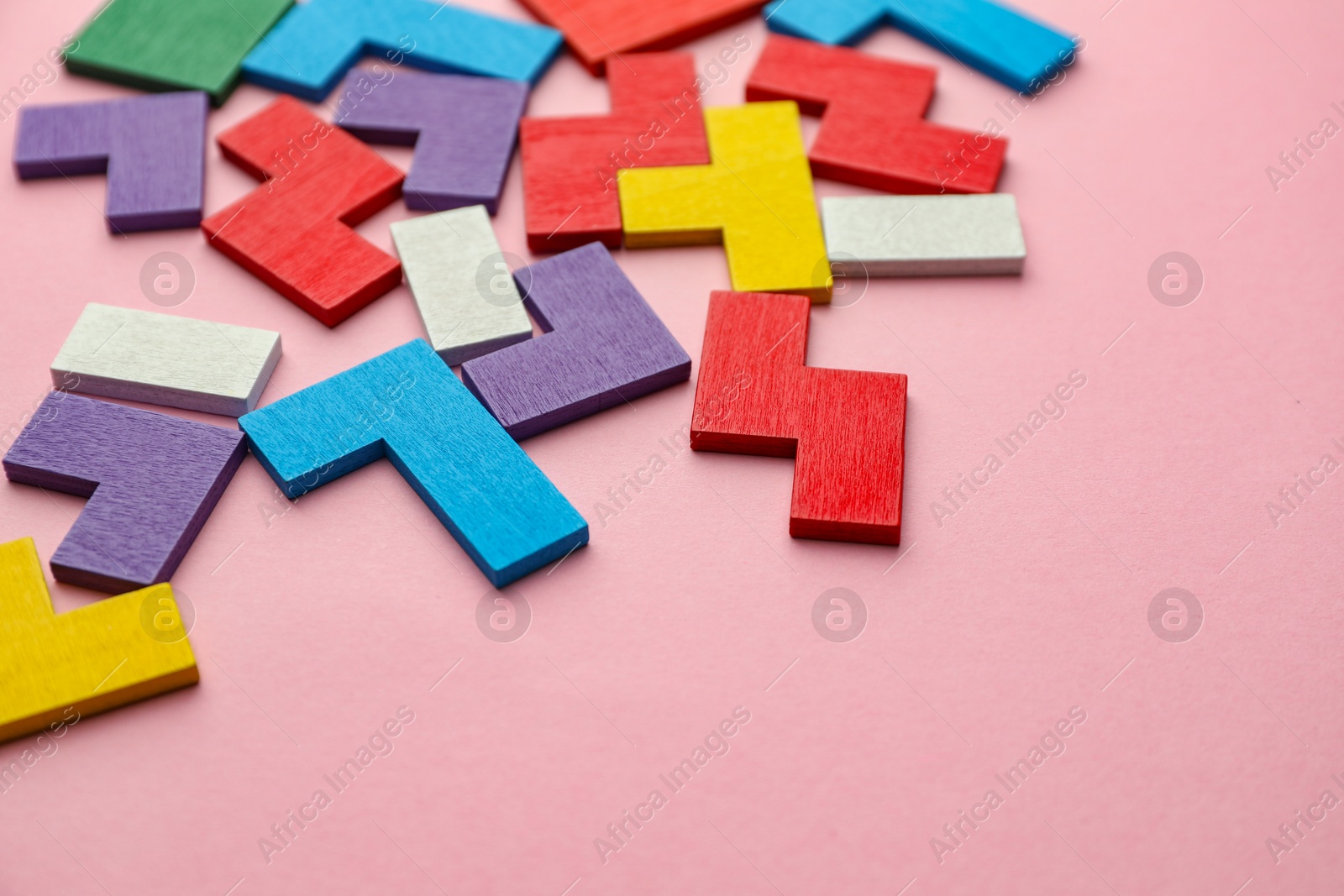 Photo of Colorful wooden puzzle pieces on pink background. Space for text