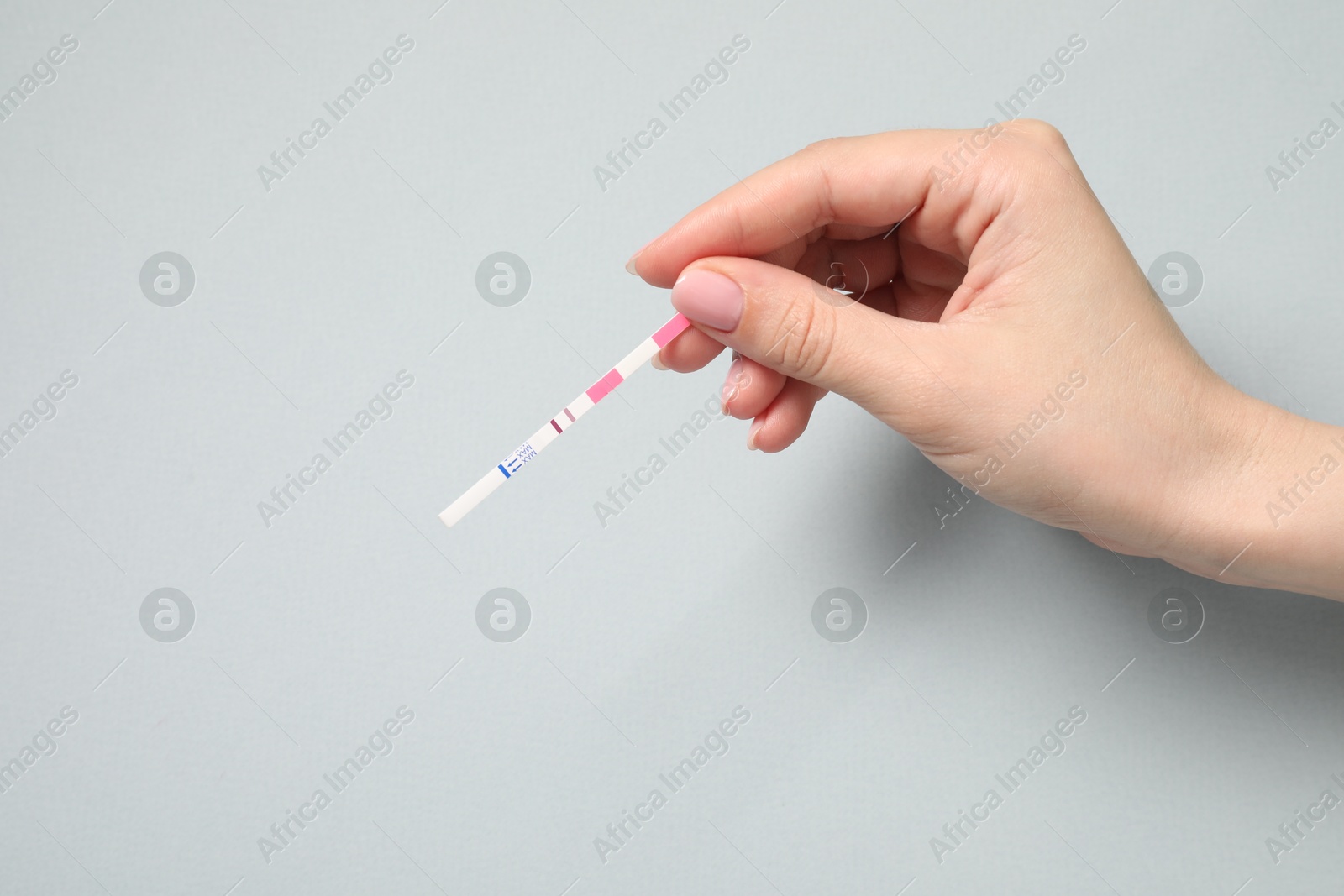 Photo of Woman with pregnancy test on light grey background, top view. Space for text