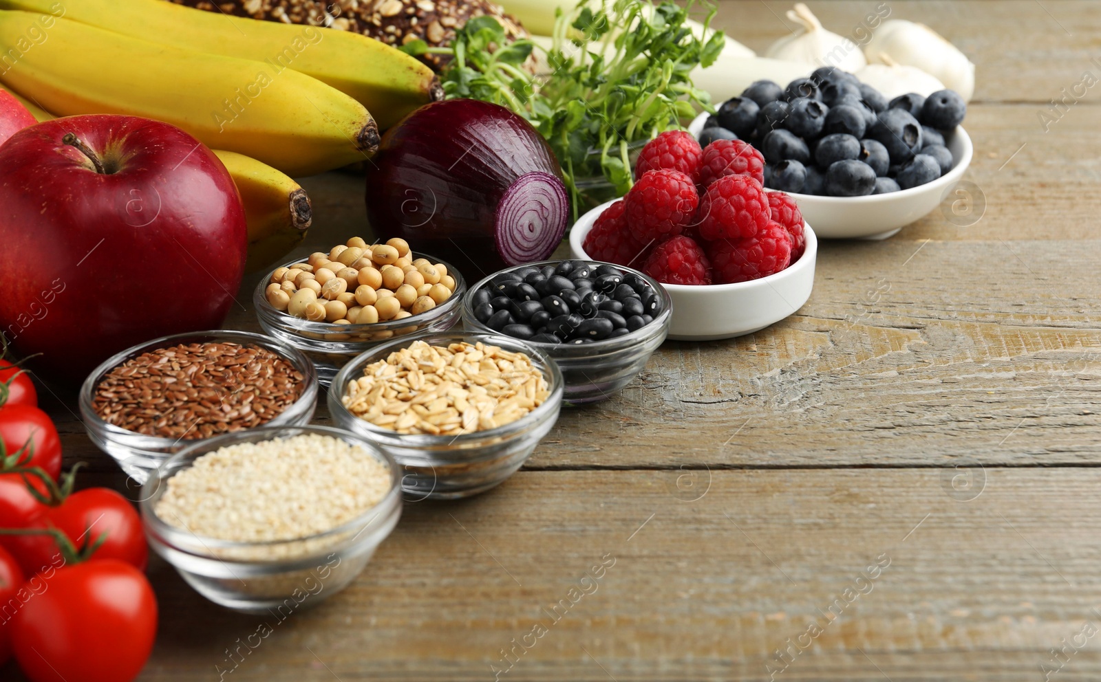 Photo of Different fresh products on wooden table, space for text. Source of prebiotics