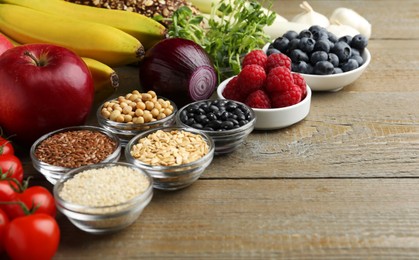 Photo of Different fresh products on wooden table, space for text. Source of prebiotics