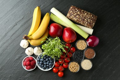 Photo of Different fresh products on black table, flat lay. Source of prebiotics