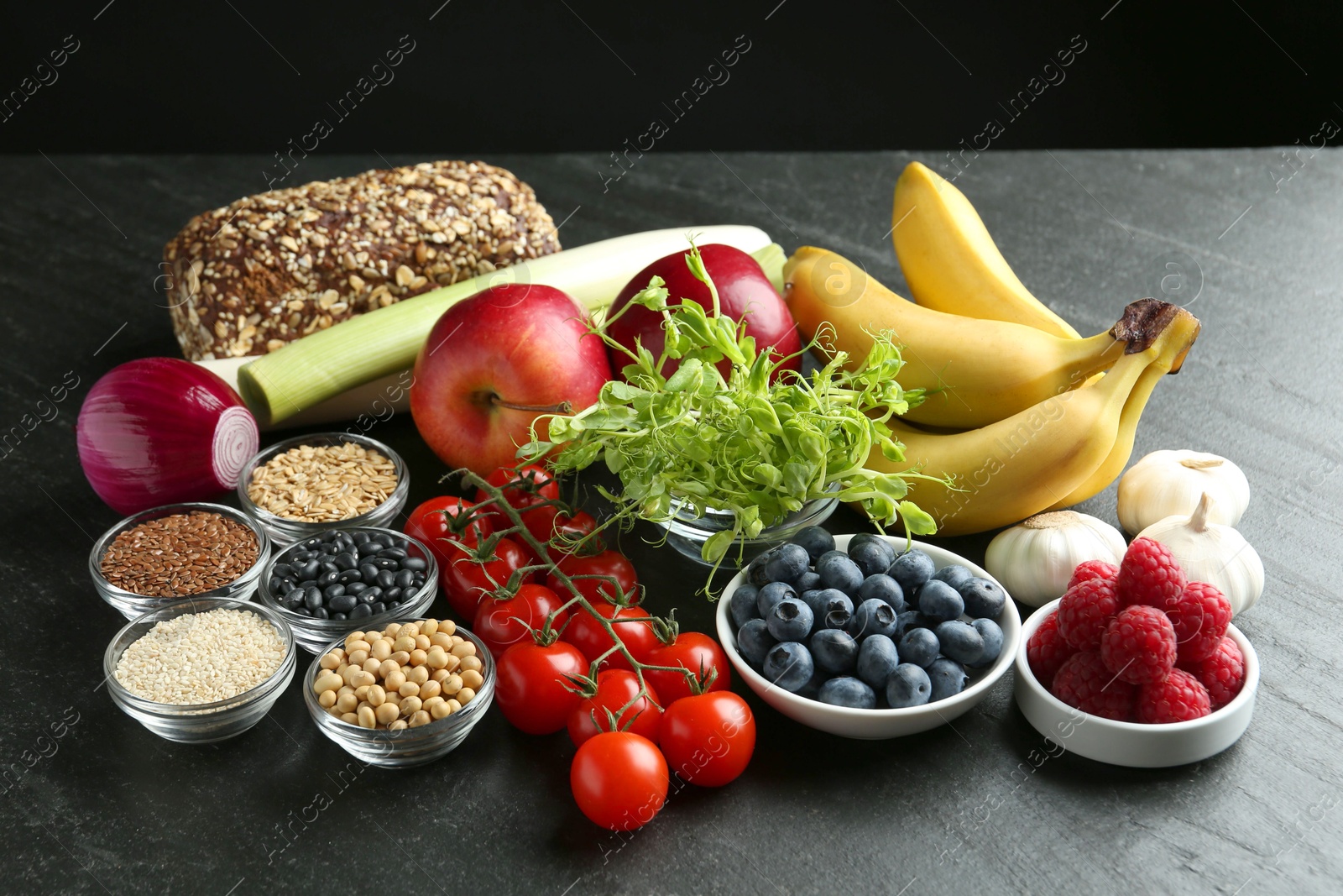 Photo of Different fresh products on black table. Source of prebiotics