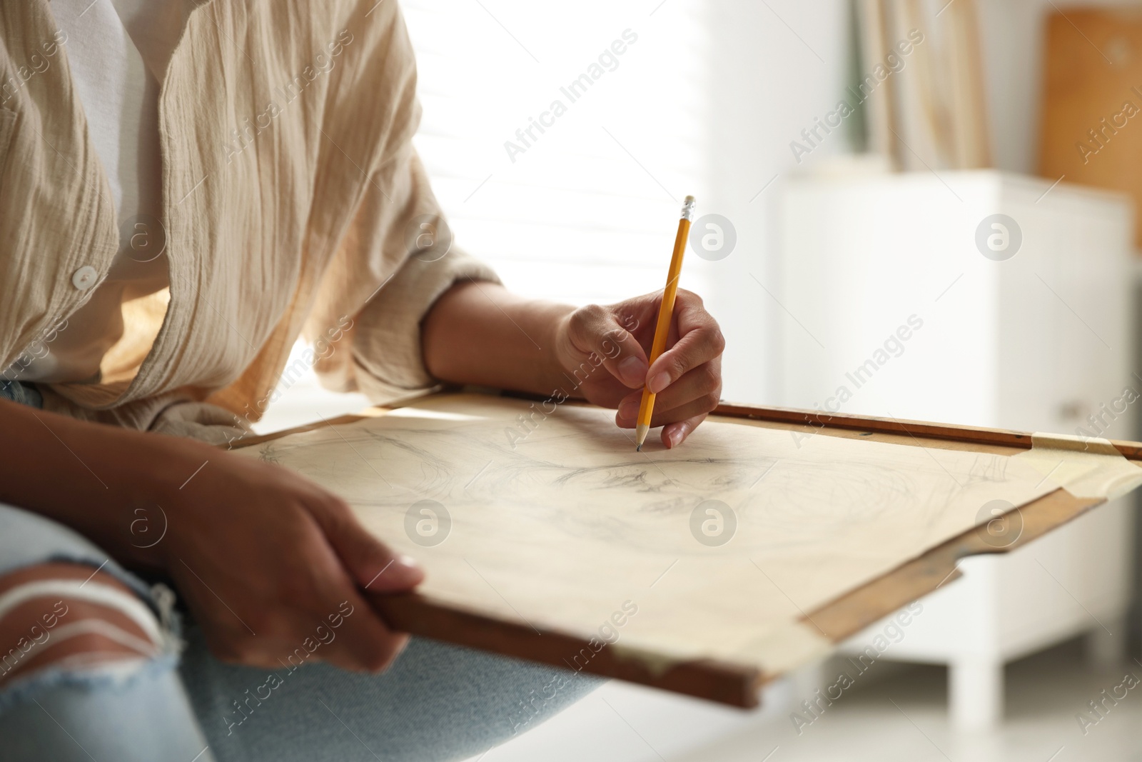 Photo of Woman drawing portrait with pencil in studio, closeup