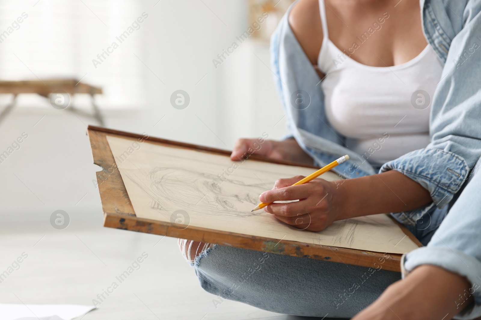 Photo of Woman drawing picture with pencil in studio, closeup