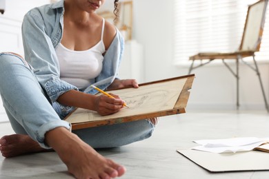 Photo of Woman drawing picture with pencil in studio, closeup