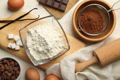 Photo of Flat lay composition with flour, eggs and other ingredients for making dough on light table