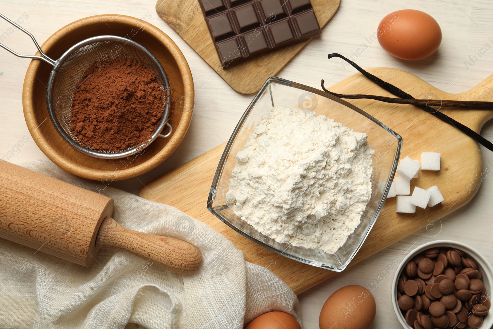 Photo of Flat lay composition with flour, eggs and other ingredients for making dough on light table