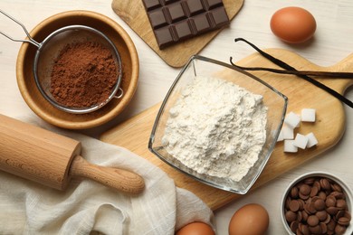 Photo of Flat lay composition with flour, eggs and other ingredients for making dough on light table