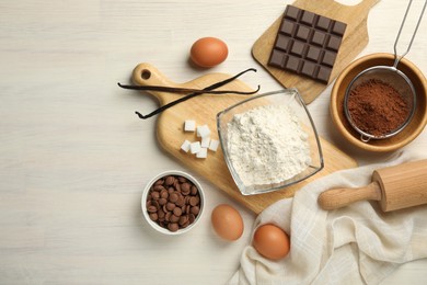 Photo of Flat lay composition with flour, eggs and other ingredients for making dough on light wooden table. Space for text