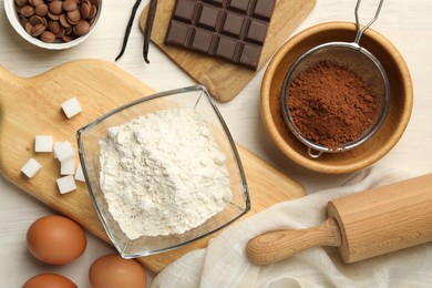 Photo of Flat lay composition with flour, eggs and other ingredients for making dough on light table