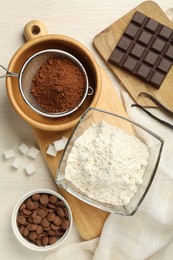 Photo of Flat lay composition with flour, chocolate and other ingredients for making dough on light table