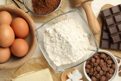 Photo of Flat lay composition with flour, eggs and other ingredients for making dough on light table