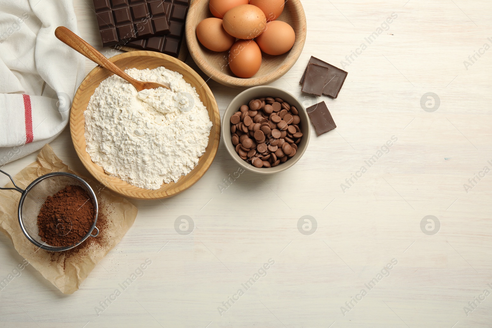 Photo of Flat lay composition with flour, eggs and other ingredients for making dough on light wooden table. Space for text