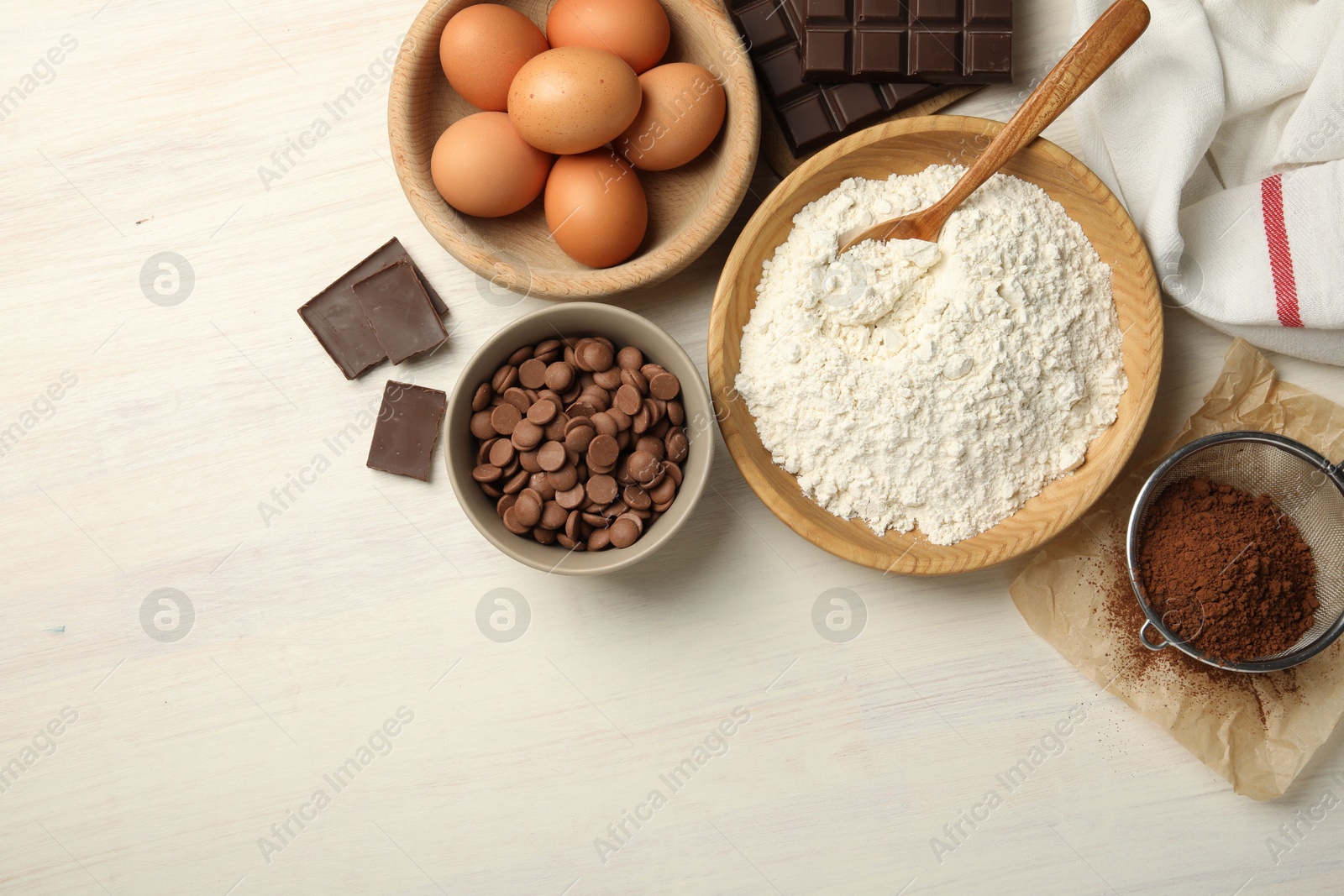 Photo of Flat lay composition with flour, eggs and other ingredients for making dough on light wooden table. Space for text