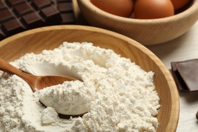 Photo of Flour in bowl for making dough on table, closeup