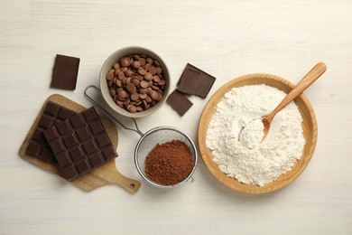 Photo of Flat lay composition with flour, chocolate and other ingredients for making dough on light wooden table