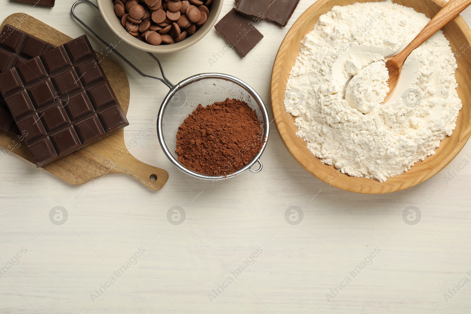 Photo of Flat lay composition with flour, chocolate and other ingredients for making dough on light wooden table. Space for text